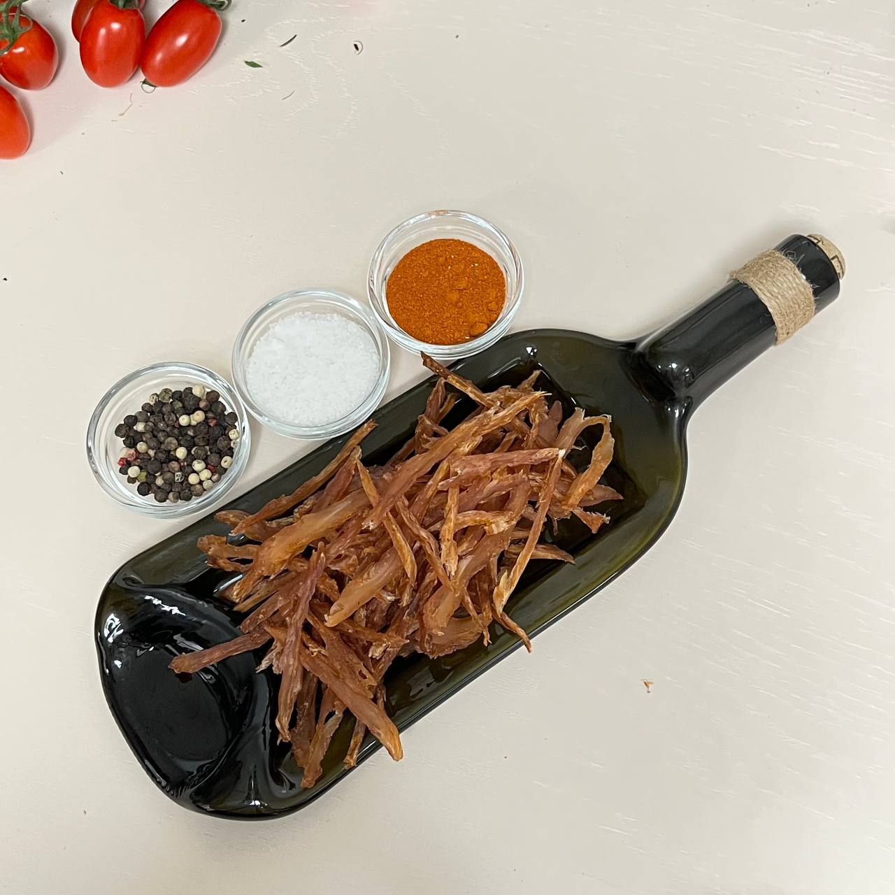 Вяленое мясо говядины и индейки на стеклянной тарелке в виде бутылки