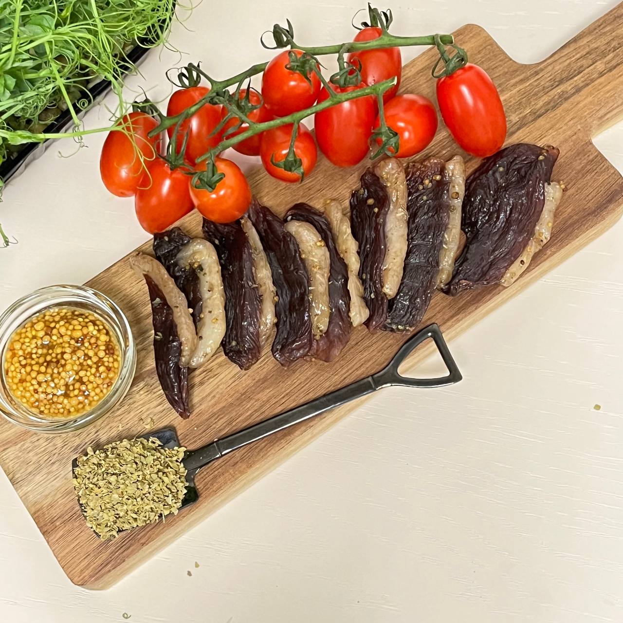 Вяленая утка на кухонной доске с красивым фоном с помидорами